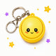 Yellow keychain with a smiley face design on a white background with decorative stars.
