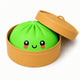 Green bun with a face in a tan container on a white background