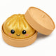 Gold glittery bun with a smiling face in a tan container on a white background
