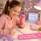 Girl holding a pink toy while studying with motivational decor in the background
