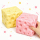 Two colorful cube-shaped sponges, one yellow and one pink, with a hand holding the pink sponge on a white background.