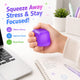 Hand holding a purple stress ball with text about relieving stress, improving focus, and boosting mood, set against a desk background.