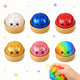 Set of colorful squishies with smiling faces in small containers on a white background.