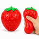 Two red strawberry-shaped objects with green tops, one held by a hand on a white background.