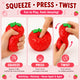 Red strawberry-shaped stress reliever with instructions on how to use it, on a pink background.